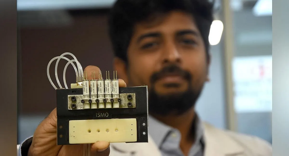 Ikram Khan holding the ISMO chip used for drug screening